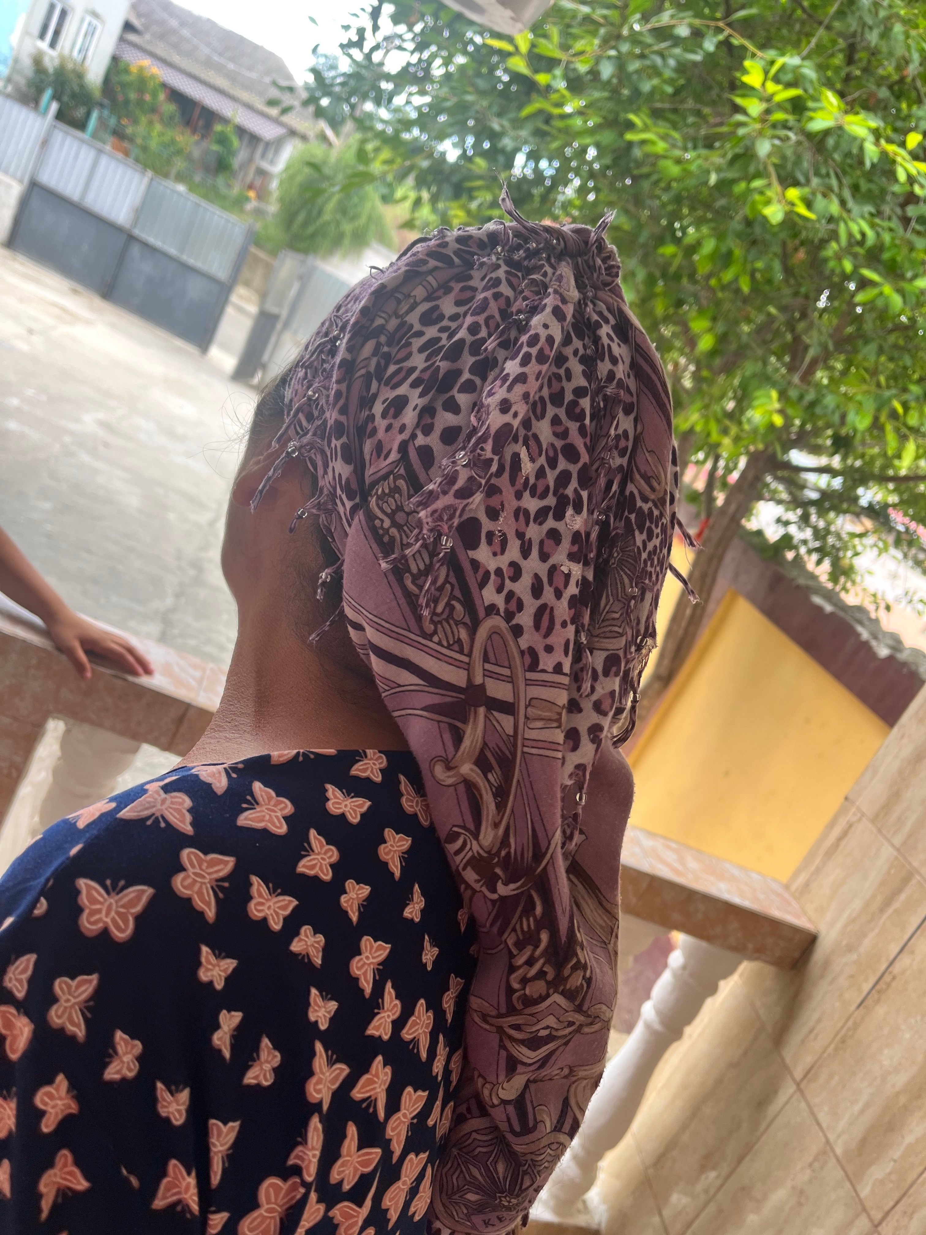 A woman from the Turkish Tinsmiths community wearing a headscarf (çember), Babadag, Tulcea County, July 2023.